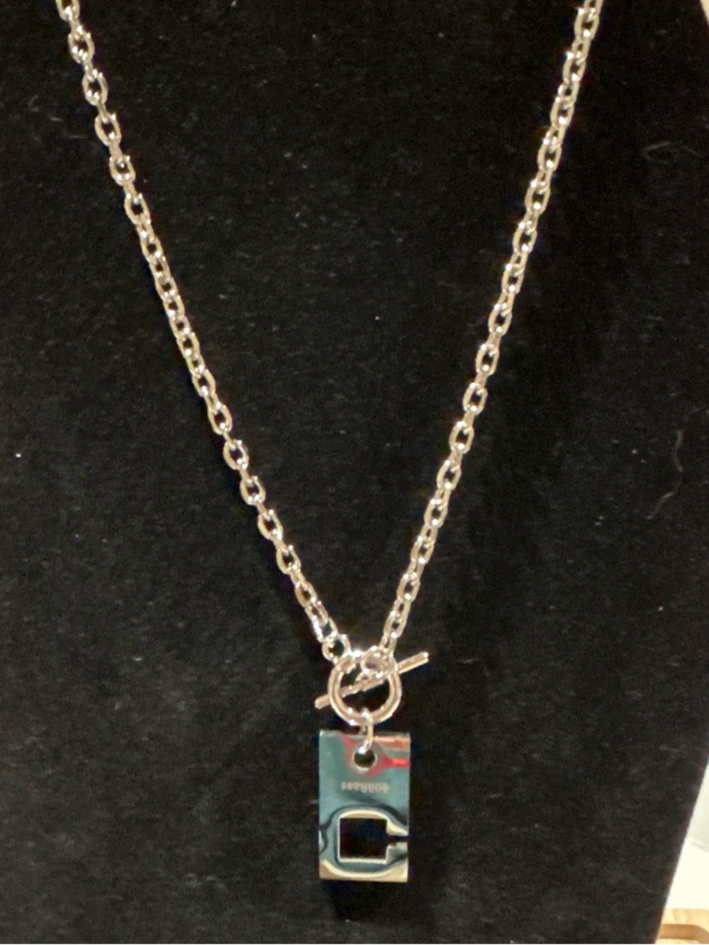 Silver color necklace with pendant written 808bass